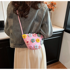 Detailed view of handmade woven crossbody bag with colorful floral embroidery on pink base