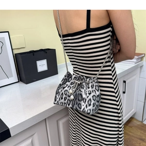 Detail of leopard print bucket bag with metal chain, pearl accents, and drawstring closure