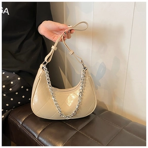 Détail d'un sac à bandoulière en cuir PU matelassé beige avec grosse chaîne argentée