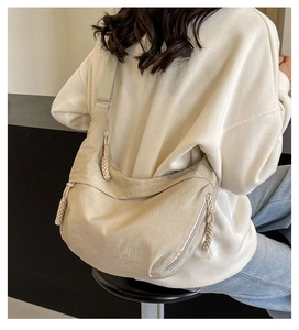 Detail view of the beige nylon dumpling bag showing large capacity and woven rope zippers