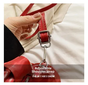 Detail view of red PU leather bag strap with silver metal buckle and swivel hook