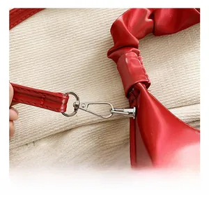Detail of red PU leather bag showing silver metal hook and strap connection
