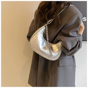 Détail du sac croissant argenté matelassé avec finition métallique et chaîne décorative