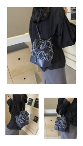 Close-up of denim bucket bag showing diamond quilting texture and leather trim details