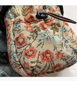 Macro shot of ethnic floral fabric texture on crossbody bag with drawstring