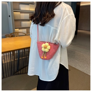 Detail of red and white checkered woven crossbody bag with sunflower decoration