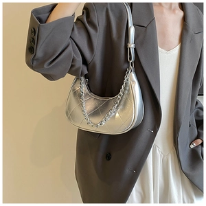 Détail d'un sac hobo argenté métallisé avec matelassage en losanges et chaîne décorative