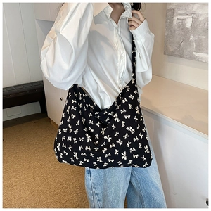 Lifestyle view of large capacity black tote bag with white bow patterns for women