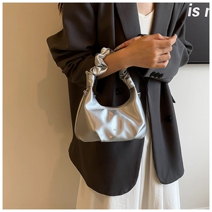 Detail of silver metallic ruched handbag with MUDUO logo and elegant ruffled handle