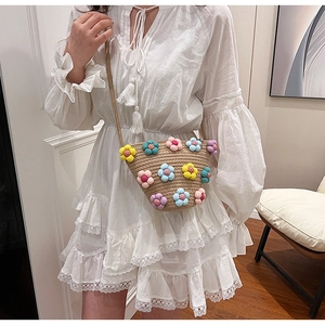 Detail of handmade straw crossbody bag with colorful plush 3D flower embellishments