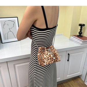 Detail of leopard print bucket bag with drawstring closure and pearl charms on metal chain