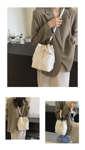 Detail view of white quilted bucket bag featuring textured fabric and drawstring closure
