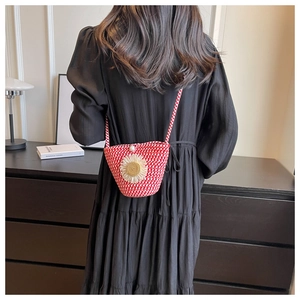 Detail of red and white woven crossbody bag with sunflower decor and pearl clasp