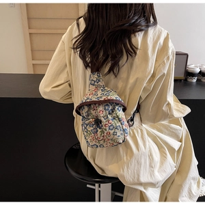 Detail of floral cross-body bag featuring jacquard fabric and drawstring closure