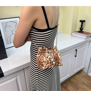 Detail of leopard print bucket bag with silver chain strap and pearl drawstring charms