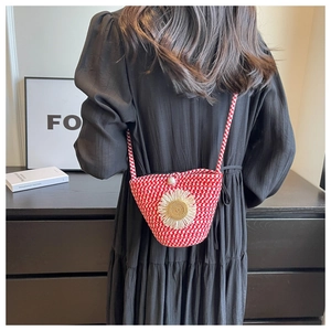 Detail of red and white woven crossbody bag with daisy flower and pearl accent