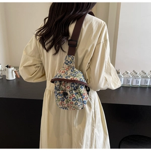 Detail shot of vintage floral crossbody bag showing jacquard texture and strap on a model