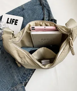 Vista interna del bolso bandolera de nailon beige con gran capacidad para objetos