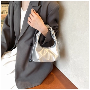 Detail of silver metallic PU leather handbag featuring a stylish scrunchie handle design