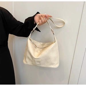 Detailed view of cream PU leather shoulder bag featuring patchwork design and square buckle