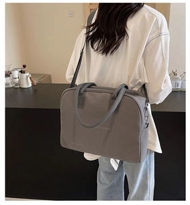Detail view of dark grey canvas tote bag with detachable strap in minimalist cafe setting