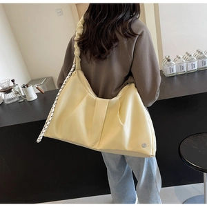 Dettaglio della borsa a nuvola plissettata beige con grande capacità e tracolla