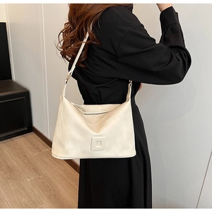 Detail of white PU leather crossbody bag with textured stitching and adjustable strap