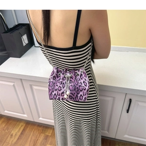 Detail of purple leopard bucket bag with white pearl charms and silver chain strap