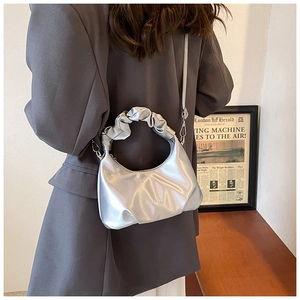 Silver crescent PU leather bag featuring unique ruched cloud handle and metallic finish