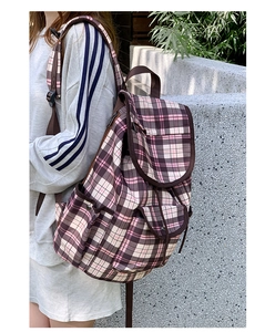 Outdoor shot of stylish pink and brown plaid nylon backpack worn by a model