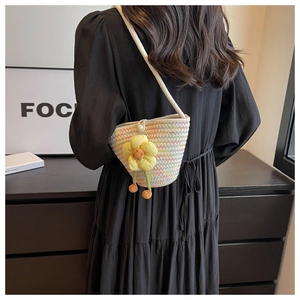 Detail of colorful woven bucket bag with 3D flower decoration and pearl button closure