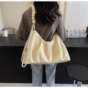 Dettaglio di una grande borsa a tracolla in nylon crema con design a nuvola pieghettata