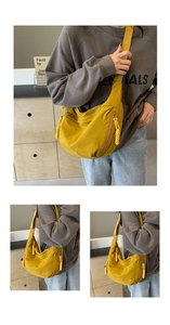 Detail view of ginger yellow crescent nylon bag showing woven zippers and adjustable strap