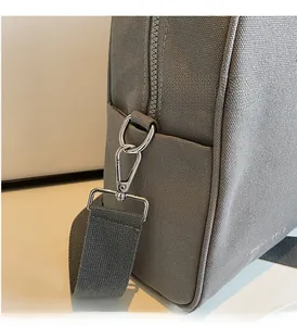 Close-up of durable gray canvas bag with silver lobster clasp and wide fabric strap