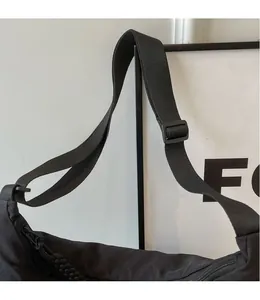 Detail of adjustable black nylon shoulder strap with buckle for versatile crossbody bag