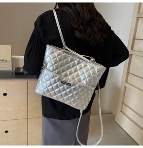 Close-up of silver quilted PU leather tote bag featuring a metallic logo plaque