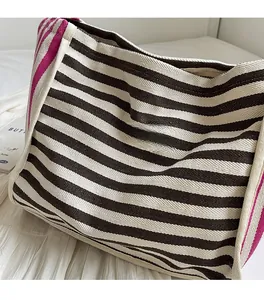 Detail of canvas tote bag with black white stripes and purple contrast trim on fabric