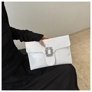 Close-up of white croc-embossed PU leather envelope clutch with rectangular diamond buckle