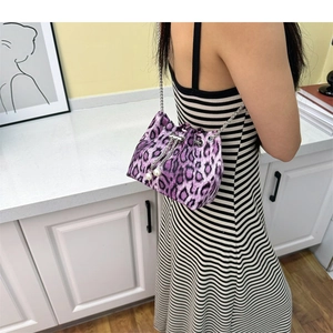 Detail of purple leopard bucket bag with silver chain strap and pearl drawstring charms