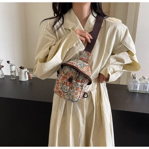 Detail of vintage floral fabric crossbody bag with drawstring pocket and brown strap