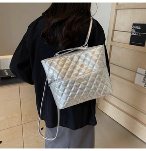 Detailed view of silver quilted PU leather handbag with metallic finish and zipper pocket