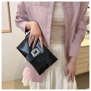 Close-up of black crocodile embossed PU leather clutch with a sparkling square crystal buckle