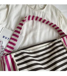 Close-up of durable purple and beige striped canvas shoulder straps on tote bag
