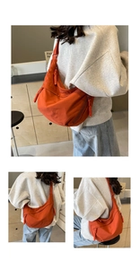 Detail view of orange nylon hobo bag featuring woven rope zipper and adjustable strap