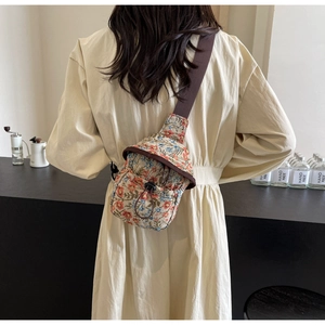 Close-up of vintage floral jacquard chest bag with brown strap and drawstring closure