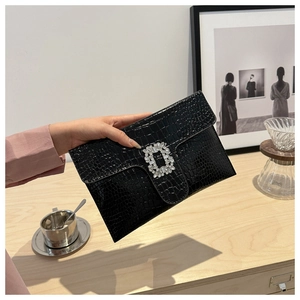 Close-up of black crocodile embossed PU leather clutch featuring a sparkling crystal buckle