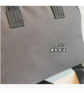 Close-up of grey canvas tote with Enjoy life and travel print and woven handle detail