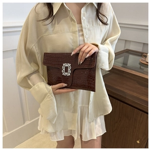 Detail of dark coffee crocodile texture PU clutch bag with luxury rhinestone buckle