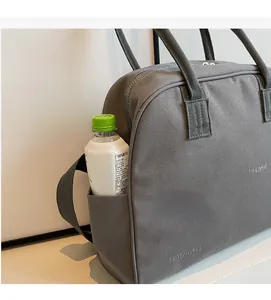 Detail of grey canvas tote bag side pocket holding a water bottle for storage