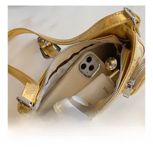 Detail view of champagne gold PU handbag interior capacity with metallic finish texture